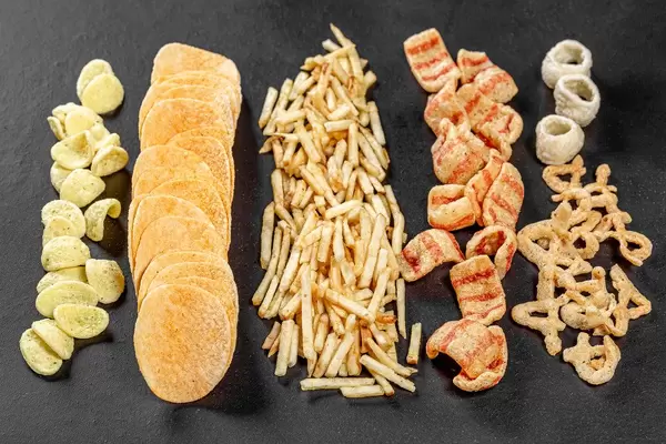 Set of potato snacks and chips on black background