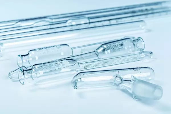 Set with different laboratory glassware for analysis on a light blue background