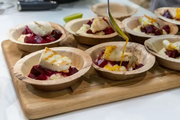Several plates of fish with vegetables and beetroot as a result of a show cooking