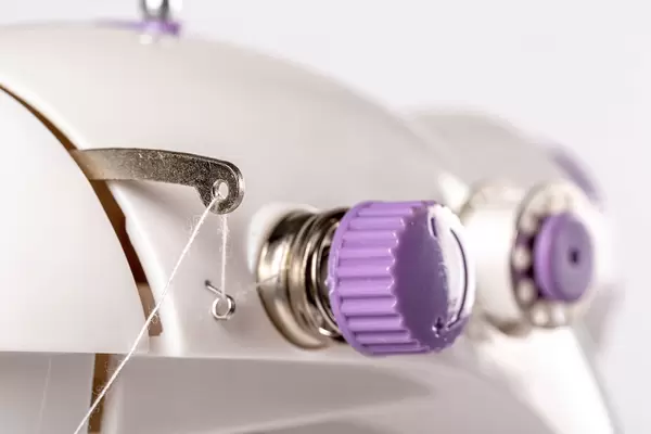 Sewing machine part with detail for stitch adjustment