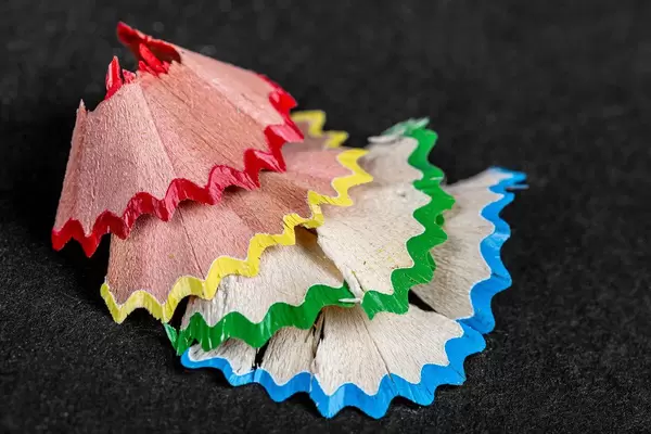Shavings of colored pencils on a black background