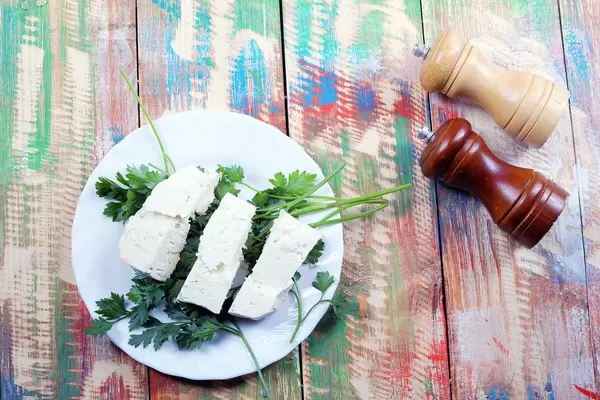 Sheep cheese, parsley, salt and pepper cellar. Wooden background (Flip 2019)