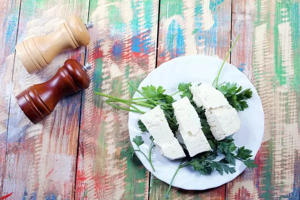Sheep cheese, parsley, salt and pepper cellar. Wooden background