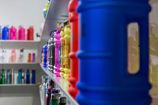Shelf with plastic sport bottles of different shapes, sizes and colors - FIBO Cologne 2018