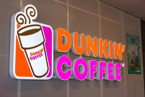 Shining neon advertising sign of the Dunkin' Coffee Logo in Barcelona, Spain