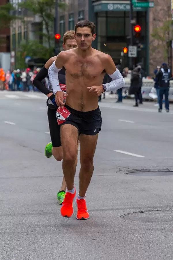 Shirtless runner in black shorts and red running shoes at the 2019 Chicago Marathon