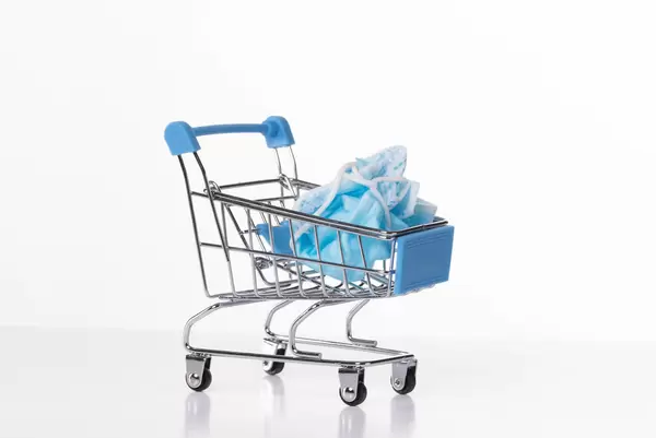 Shopping cart with used medical face mask