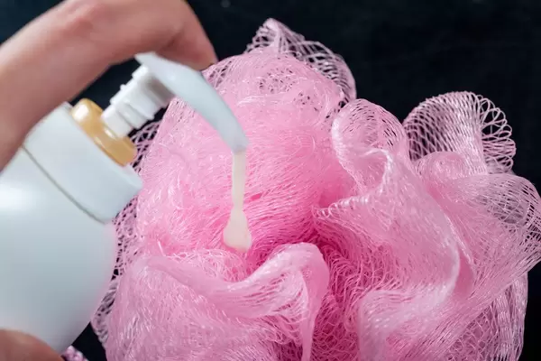Shower gel is poured on the washcloth