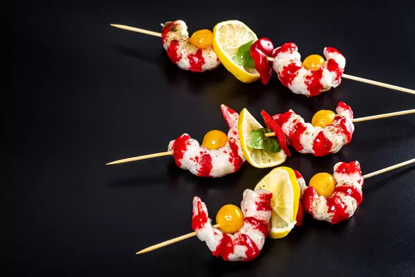 Shrimp on wooden sticks with vegetables