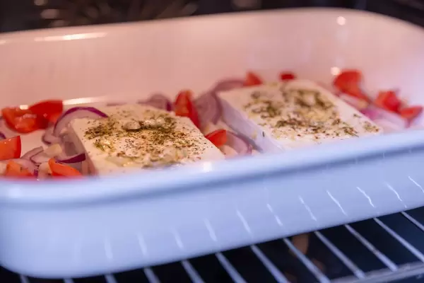 Sicht im Backofen auf Gebackenen Hirtenkäse mit Tomaten und Zwiebeln