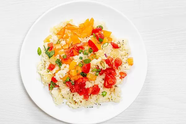 Sicht von oben auf Couscous-Salat mit bunter Paprika, Frühlingszwiebeln und Chea-Samen