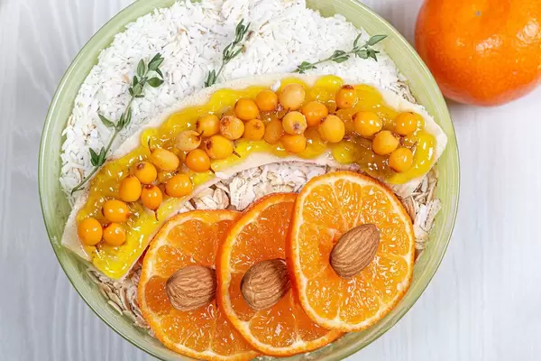 Sicht von oben auf ein gesundes Frühstück mit Haferflocken, Früchten und Kokosnuss