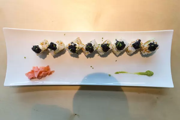 Sicht von oben auf japanisches Sushi "Lucky No Fish", mit veganem Thunfisch und veganem Kaviar, scharfer Sauce, Kimchi-Sesam und Avocado