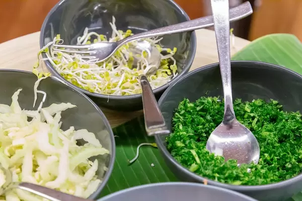 Side dishes at lunch with green herbs and sprouts in bowls during the Barcamp OMWest19 by AXA in Cologne