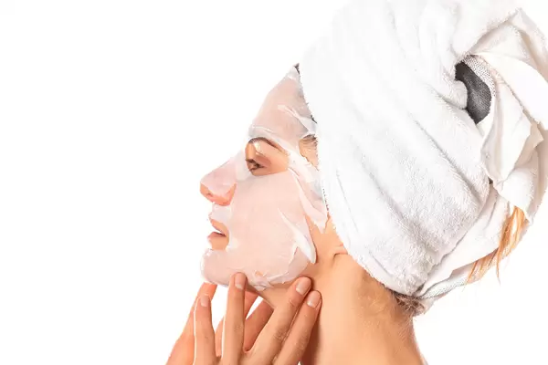 Side view of woman with cosmetic cloth mask on face