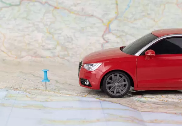 Sie haben Ihr Ziel erreicht. Auto und Stecknadel auf einer Landkarte