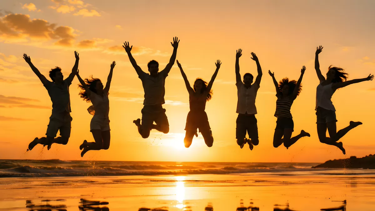 Sieben Freunde springen bei Sonnenuntergang am Strand