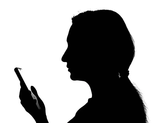 silhouette of a businesswoman using a smartphone