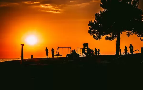 Silhouetten mehrerer Menschen beim Sonnenuntergang