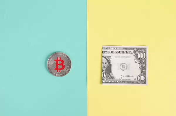 SIlver Bitcoin coin and folded dollar banknote