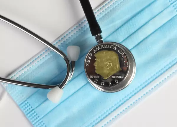 Silver coin with Donald Trump and stethoscope on face mask