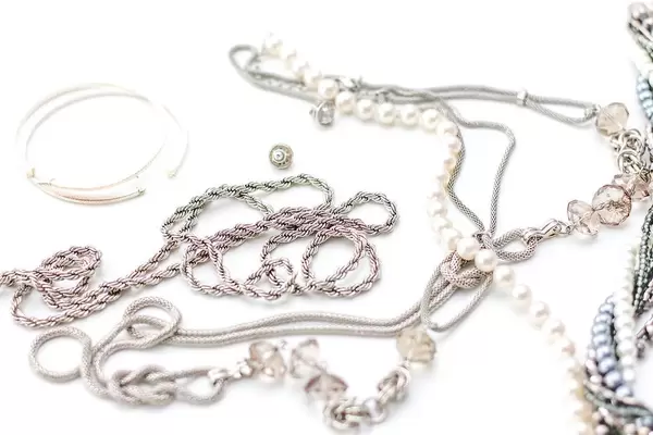 Silver jewelry and pearl bracelet on white background