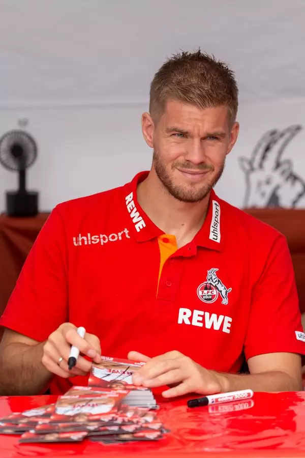 Simon Terodde signiert Autogrammkarten für Fans