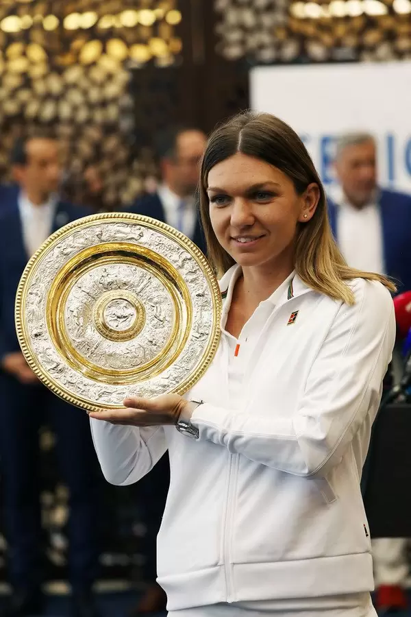 Simona Halep, the 2019 Wimbledon winner, presents the trophy