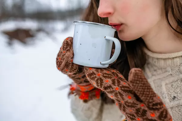 Sipping Tea On MEtal Cup Wintertime Outdoors