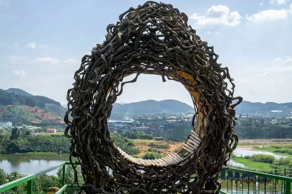 Sitz aus Baumwurzeln und Ästen für ein Fotoshooting mit Bergen und einem See im Hintergrund in Dalat, Vietnam