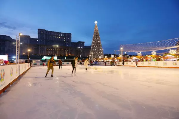 Skate rink at Bucharest Christmas market, The Palace of Parliament on background