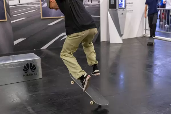 Skater am Huawei Stand führt an der Photokina einen Trick mit dem Skateboard vor