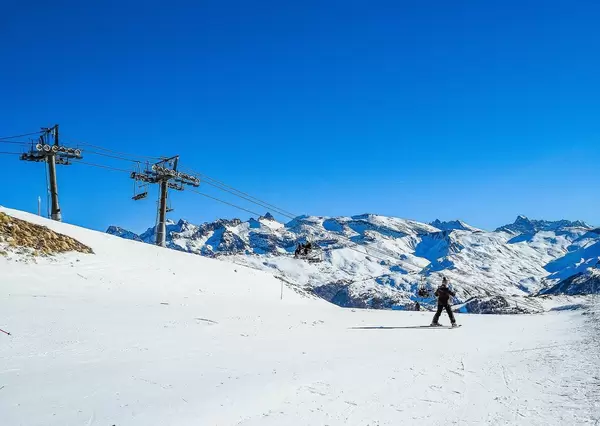 Skifahrer auf Skipiste neben Skilift in Alpen bei Vars, Frankreich