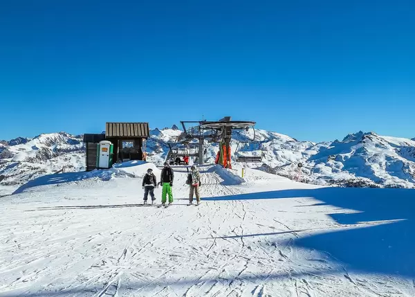 Skifahrer verlassen Sessellift an Gipfel in Wintersportgebiet Vars, Frankreich