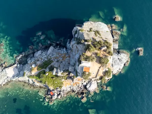 Skopelos: Bird's eye view of the chapel of Agios Ioannis set atop a rock formation surrounded by the sea