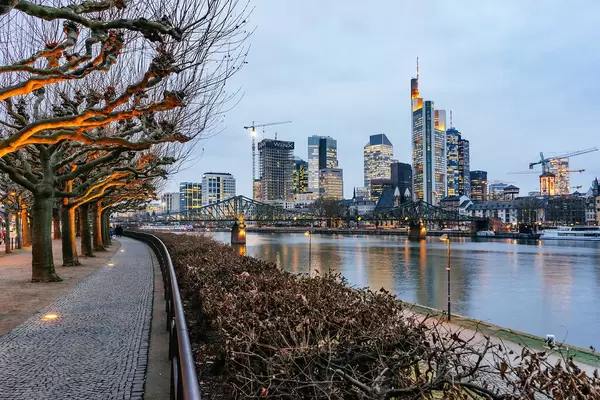 Skyline of Frankfurt with skyscrapers, bridge and promenade along the river Main with bare trees and no persons