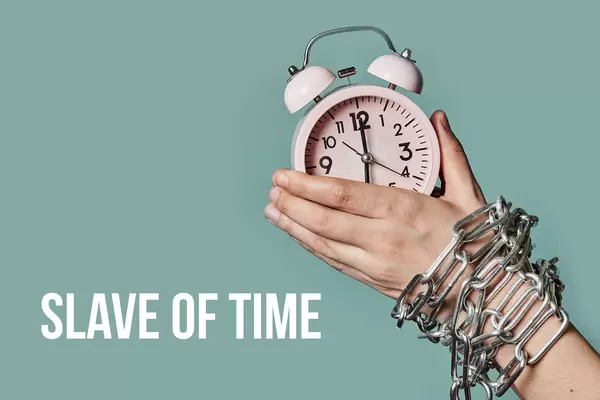 Slave of time concept with chained arm and alarm clock