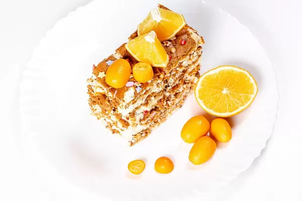Slice of cake with condensed milk, nuts and citrus, top view (Flip 2020)