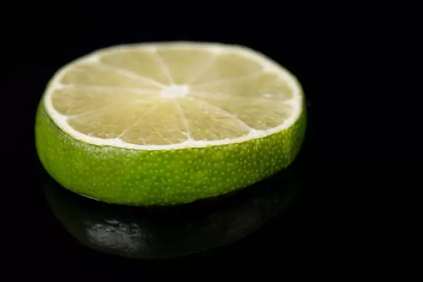 Slice of Lime fruit on the black reflective background (Flip 2019)