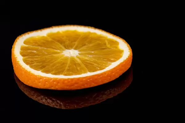 Slice of Orange fruit on the black reflective background (Flip 2019)