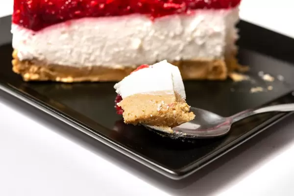 Slice on the spoon of Cheesecake with Raspberry cream