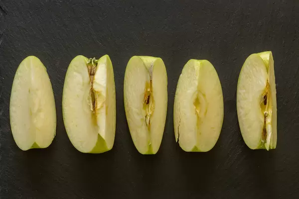 Sliced Apple above black background
