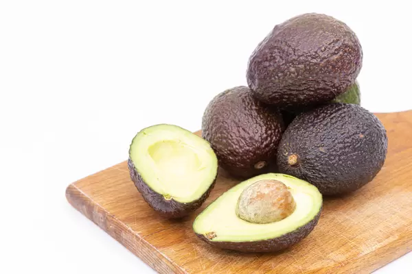 Sliced Avocados on the wooden board with copy space above white background