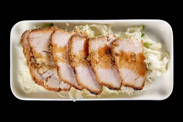 Sliced baked meat with cabbage salad with cucumber, top view