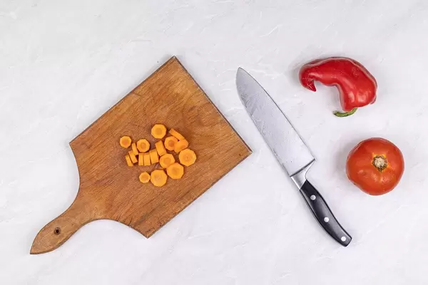 Sliced Carrot on the wooden board with Tomato and Paprika