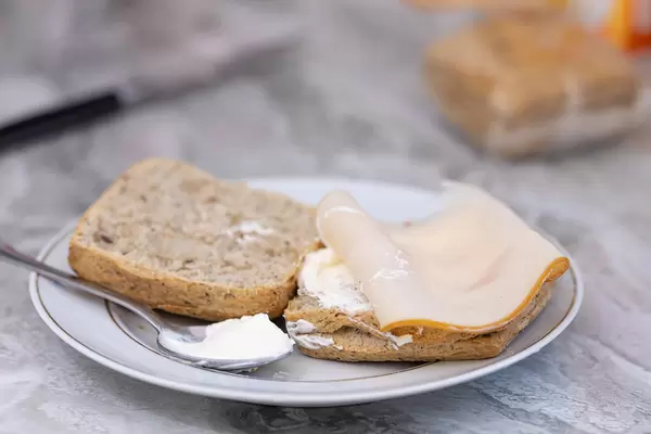 Sliced dark Bread served on the plate with cheese cream and ham