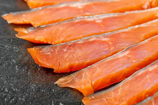Sliced fillet of smoked red fish on a black background (Flip 2020)