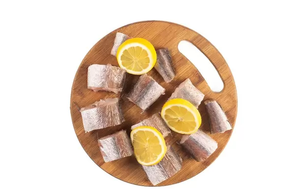 Sliced Hake Fish on the wooden board with Lemon