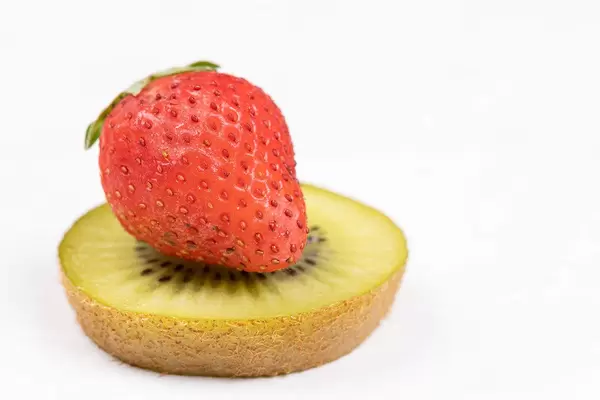 Sliced Kiwi and Strawberry above white background