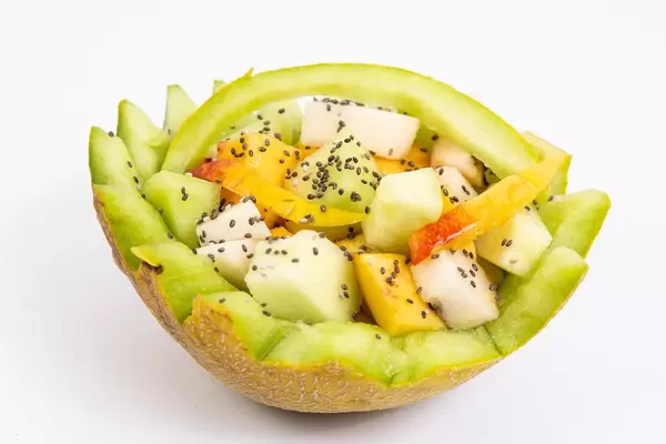 Sliced Melon and Peach with Chia seeds above white background